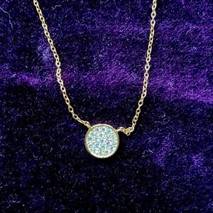 Gold plated necklace with round attached pendant with crystals.